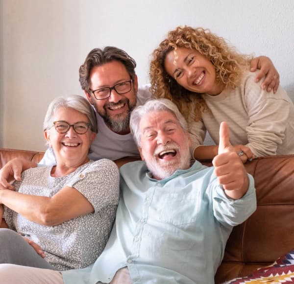 Three generations of a family laughing together on a couch